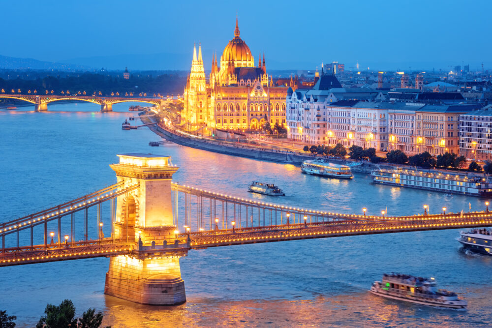 Budapest city, Hungary, view of the Chain bridge over Danube river and Parliament building glowing gold in blue evening light