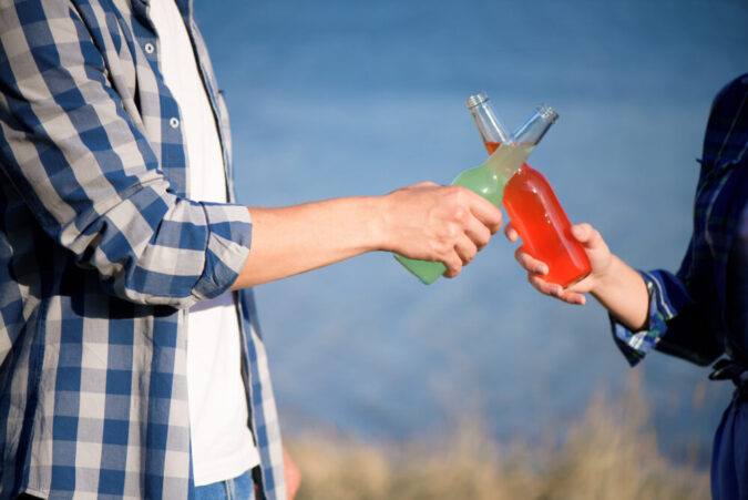 Young couple in love enjoying cocktail at the beach